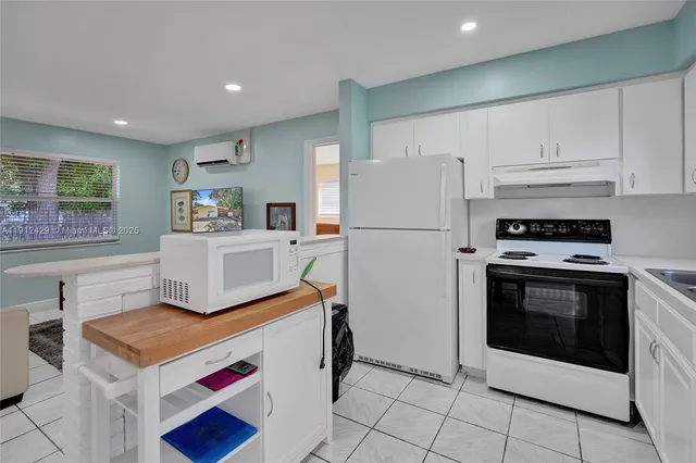 a kitchen with white cabinets and white appliances