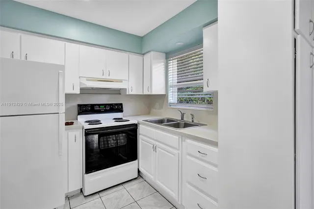 a white refrigerator freezer and a stove sitting inside of a kitchen