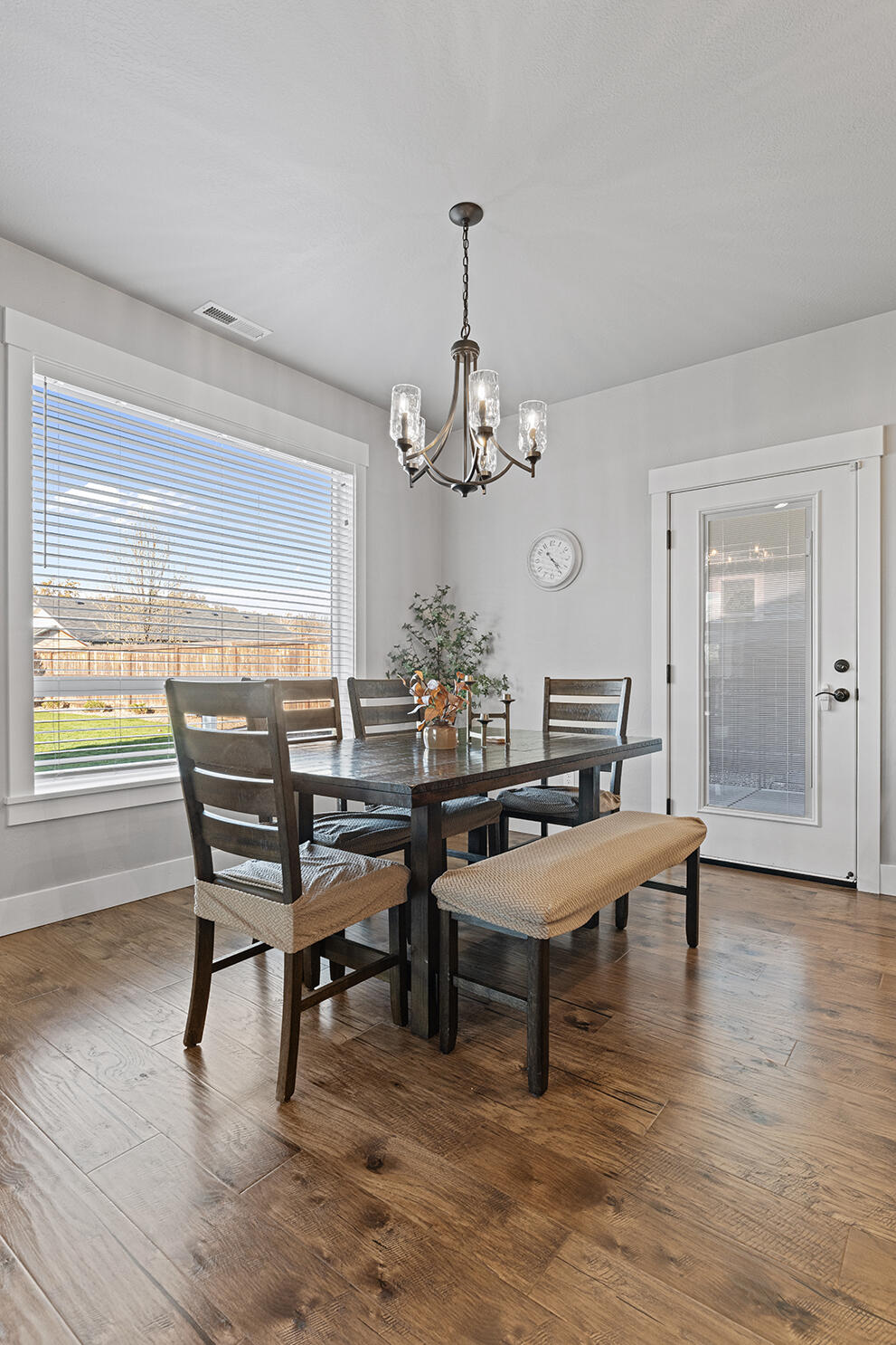 1043 Arrowhead Trail Eagle Point, OR 97524 - Photo 4 of 29 a dining room with wooden floor a chandelier a wooden table and chairs
