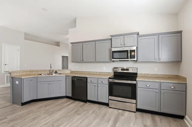a kitchen with sink a microwave and cabinets