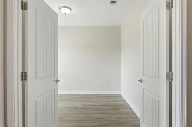 a view of a hallway with wooden floor