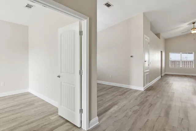 a view of a hallway with wooden floor