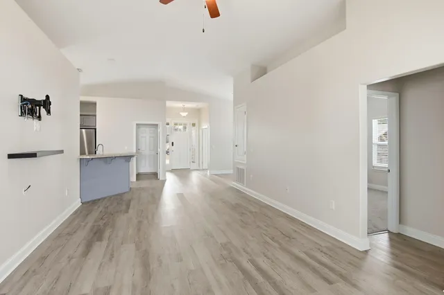 a view of a big room with wooden floor and windows