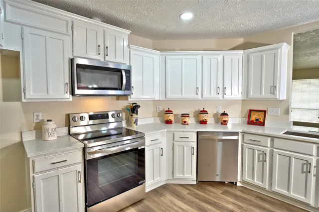 a kitchen with cabinets appliances and a window