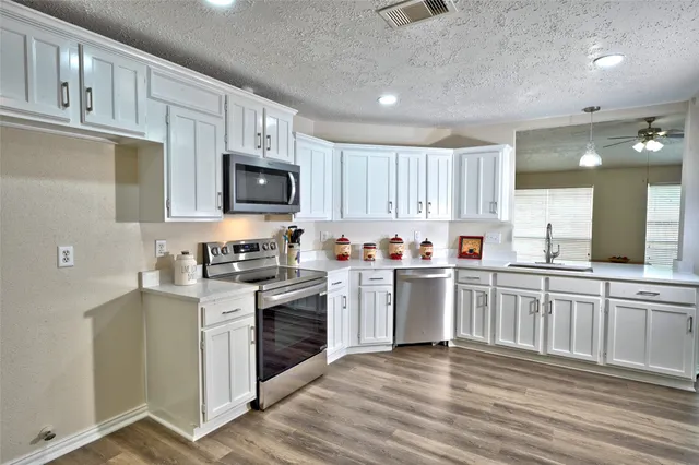 a kitchen with granite countertop cabinets stainless steel appliances and a sink