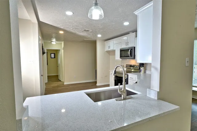 a kitchen with kitchen island a sink stainless steel appliances and a counter top space