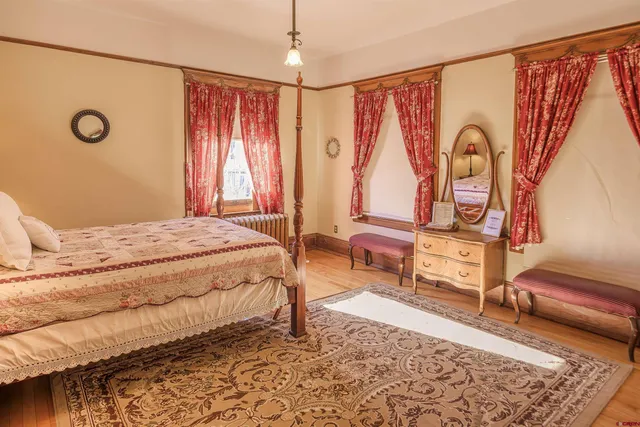 a bedroom with a bed a dresser and chair