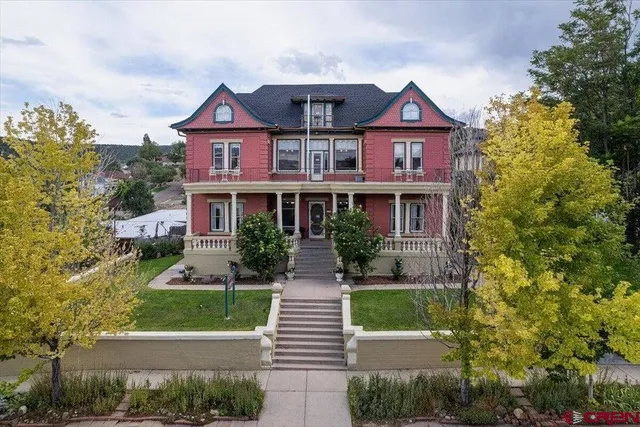 a front view of a house with a yard and potted plants