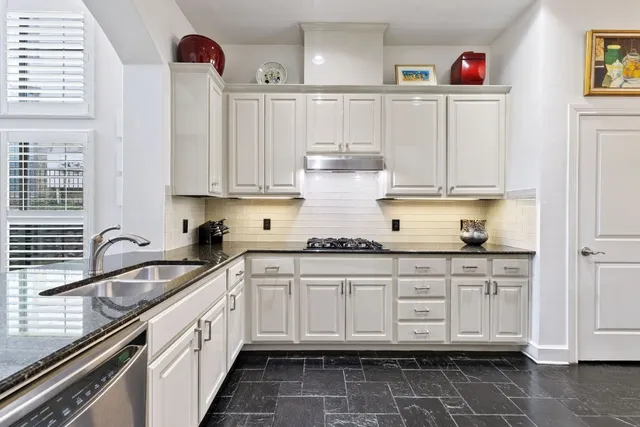 a kitchen with granite countertop a sink and cabinets