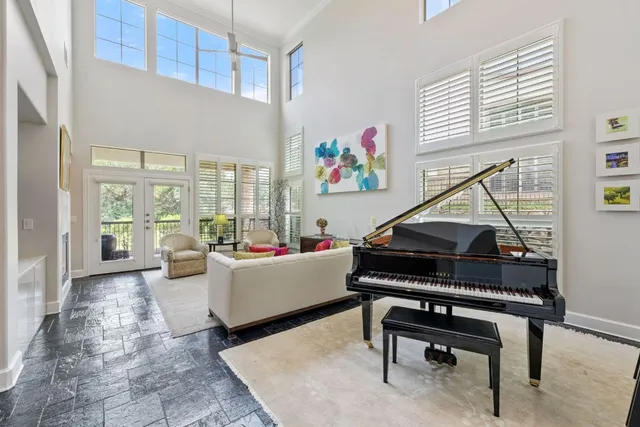 a living room with furniture a piano and a window