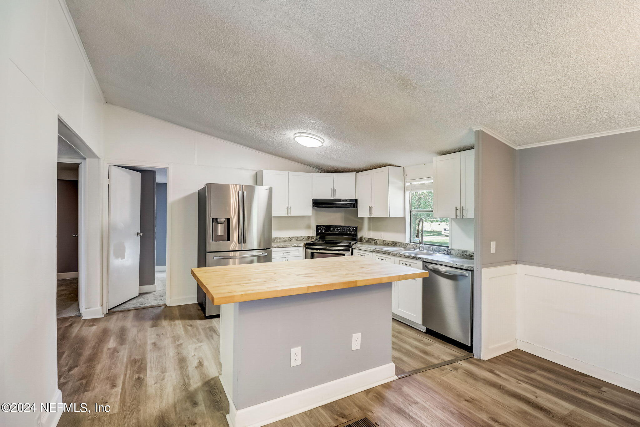54262 Vikki Road Callahan, FL 32011 - Photo 12 of 48 a kitchen with stainless steel appliances granite countertop a stove a refrigerator a sink dishwasher and a oven with white cabinets