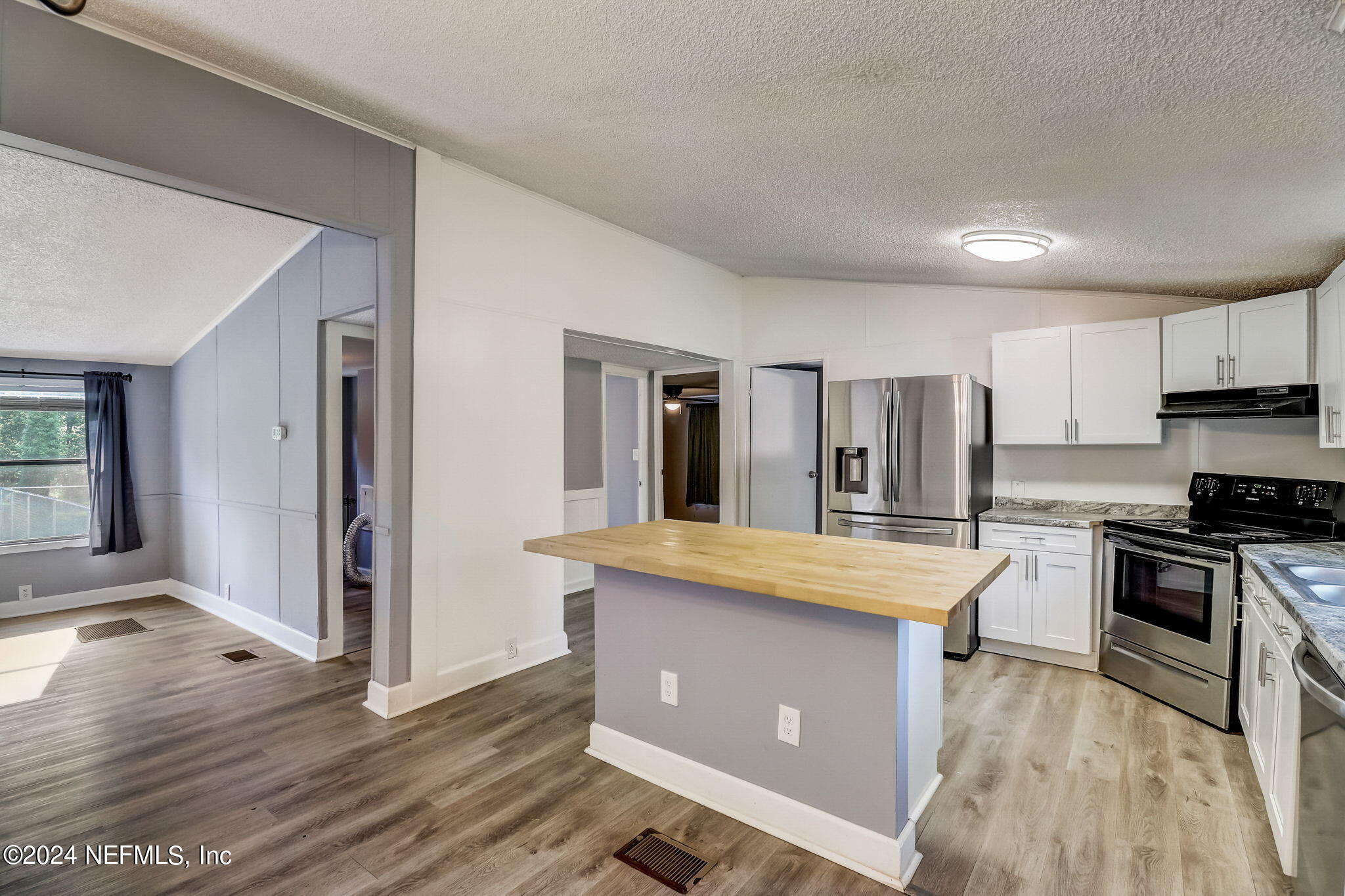 54262 Vikki Road Callahan, FL 32011 - Photo 13 of 48 a kitchen with stainless steel appliances granite countertop a stove top oven a refrigerator a sink and dishwasher with wooden floor