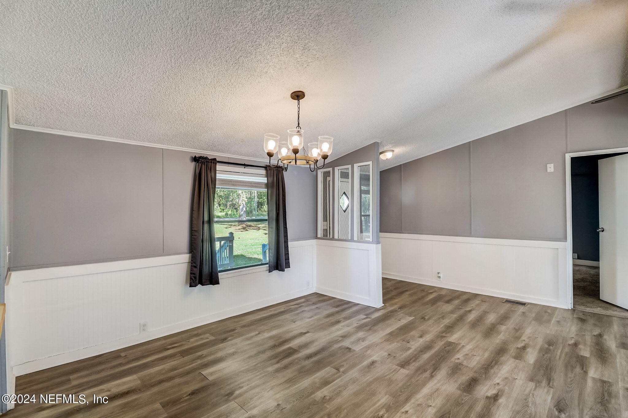 54262 Vikki Road Callahan, FL 32011 - Photo 10 of 48 a view of an empty room with window and chandelier