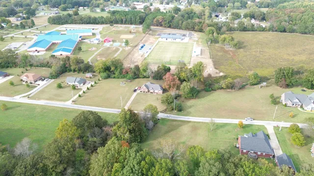 an aerial view of residential houses with outdoor space and lake view