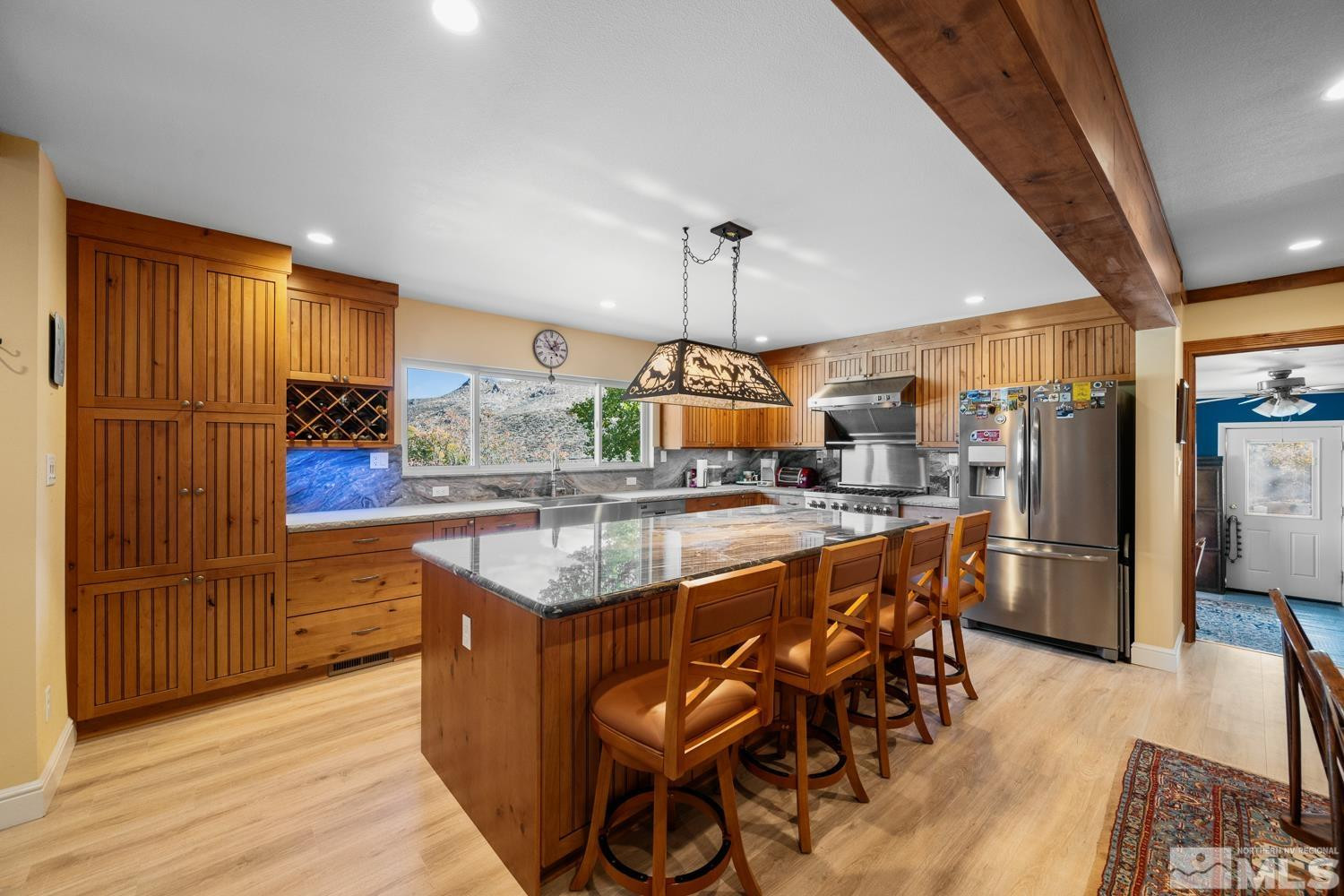 14005 North Red Rock Road Reno, NV 89508 - Photo 16 of 39 a kitchen with stainless steel appliances granite countertop a table chairs sink and wooden floor
