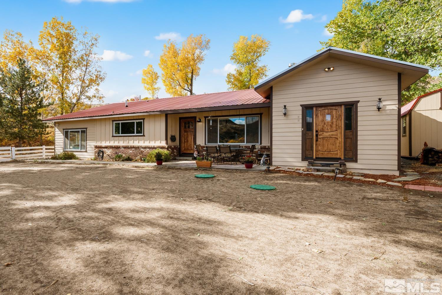 14005 North Red Rock Road Reno, NV 89508 - Photo 35 of 39 a view of a white house with large windows and a yard