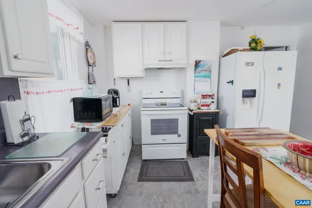 a kitchen with white cabinets and white appliances