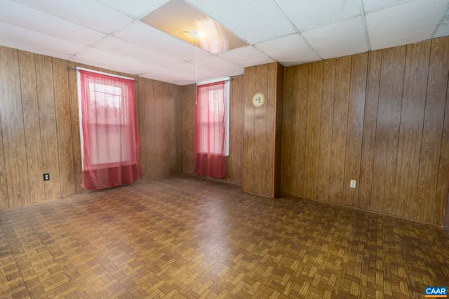 a balcony with wooden floor and yard in the back