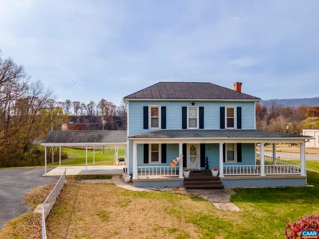 a view of house with a big yard and potted plants