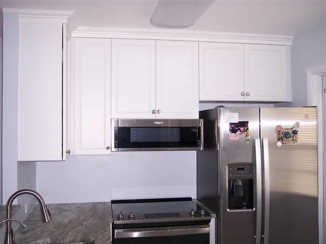 a kitchen with granite countertop a sink stove and refrigerator