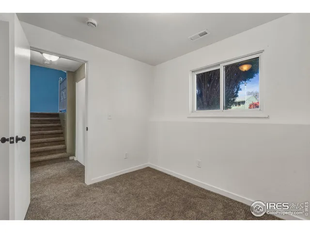 a view of an empty room with closet and a window