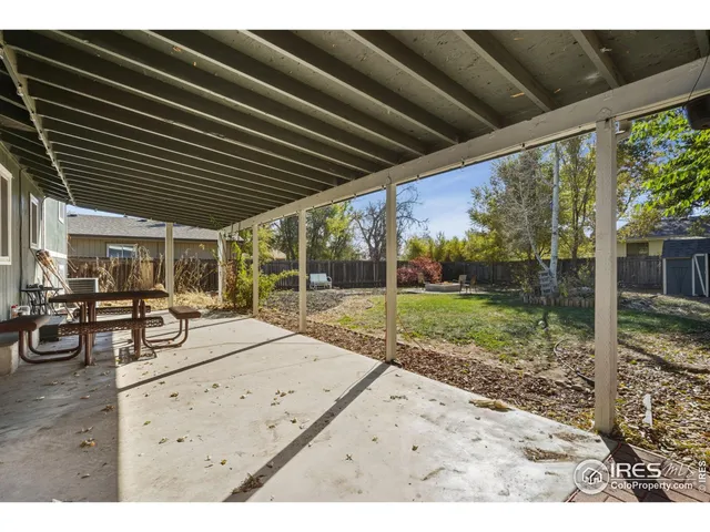 a view of a backyard with table and chairs with wooden floor and fence