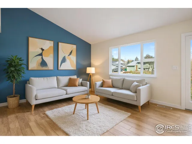 a living room with furniture and a painting on the wall
