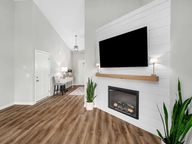 a living room with furniture a fireplace and a flat screen tv