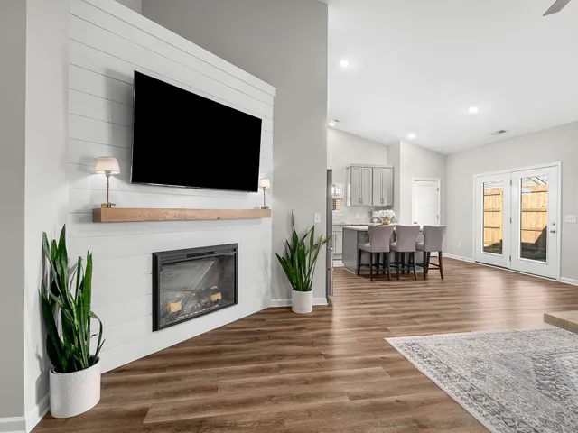 a living room with furniture a fireplace and a flat screen tv