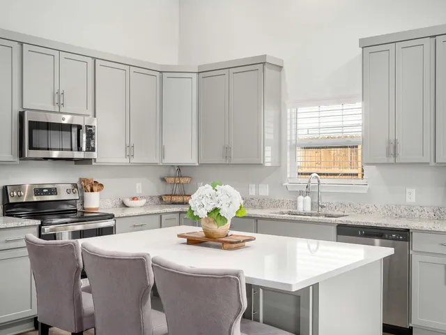 a kitchen with stainless steel appliances granite countertop a sink a stove a microwave a refrigerator and cabinets