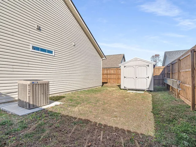 a view of a house with backyard and wooden fence