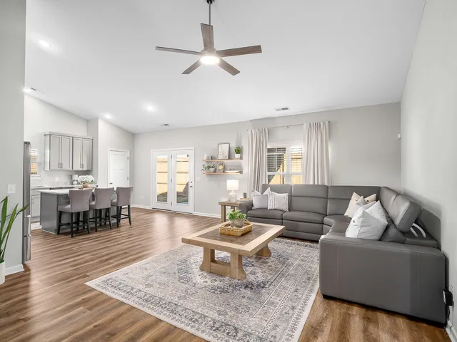 a living room with furniture and a wooden floor