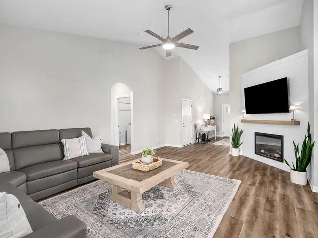 a living room with furniture a fireplace and a flat screen tv