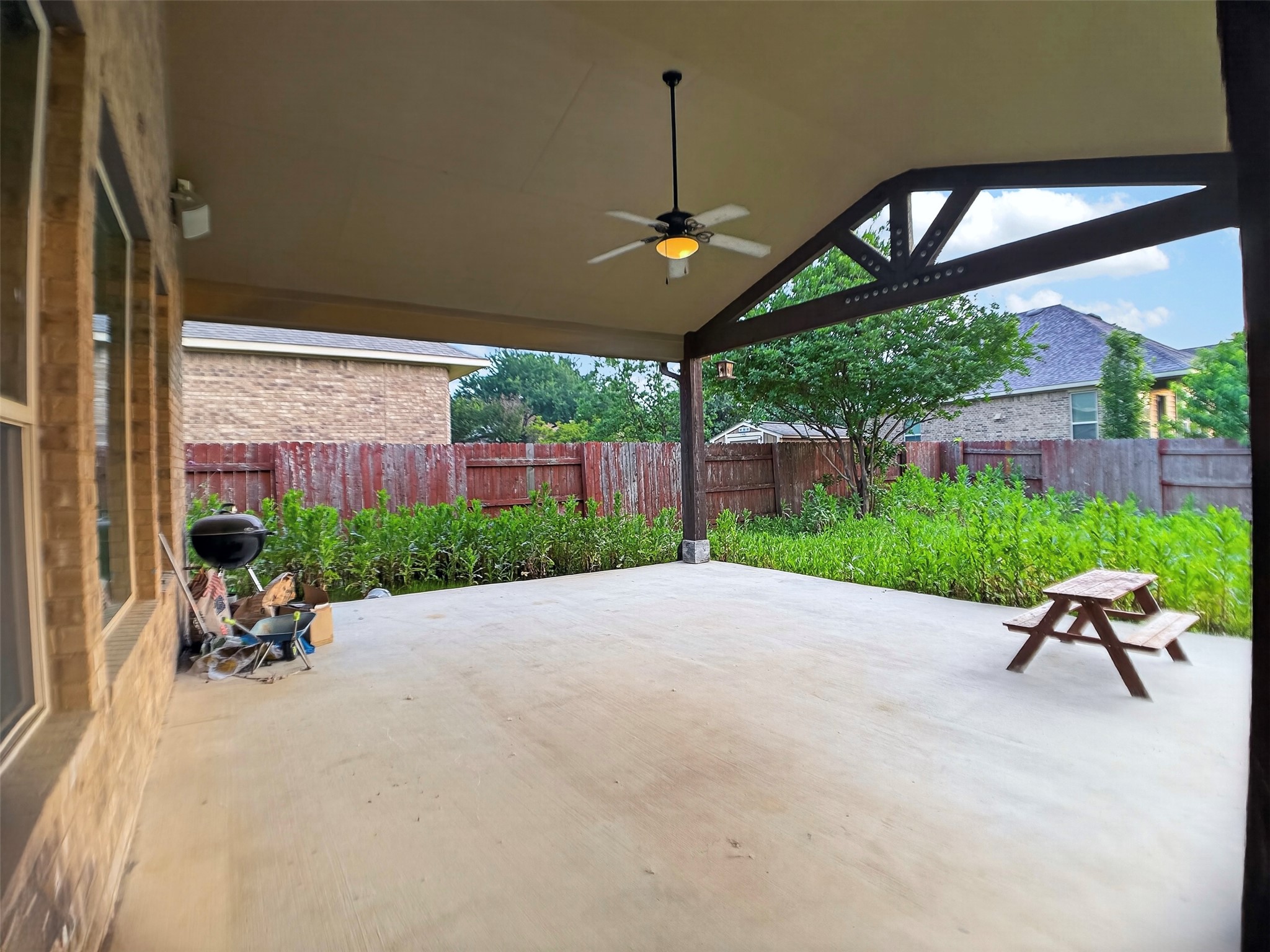 1505 Long Shadow Lane Georgetown, TX 78628 - Photo 27 of 28 Covered patio featuring a concrete slab and exposed wood beam ceiling with a ceiling fan