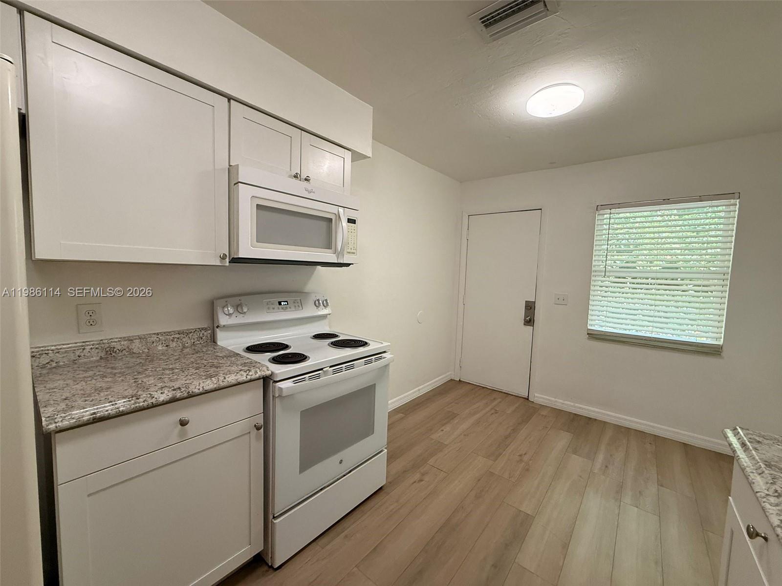 2919 Jackson Street, Unit 4 Fort Myers, FL 33901 - Photo 5 of 13 a kitchen with granite countertop cabinets stainless steel appliances and wooden floor