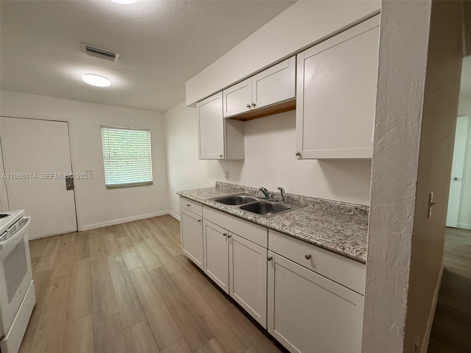 2919 Jackson Street, Unit 4 Fort Myers, FL 33901 - Photo 6 of 13 a kitchen with granite countertop wooden cabinets and a stove