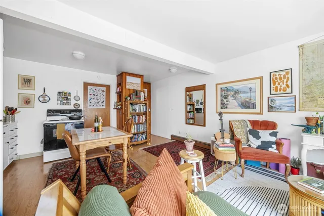 a living room with furniture a rug and wall painting