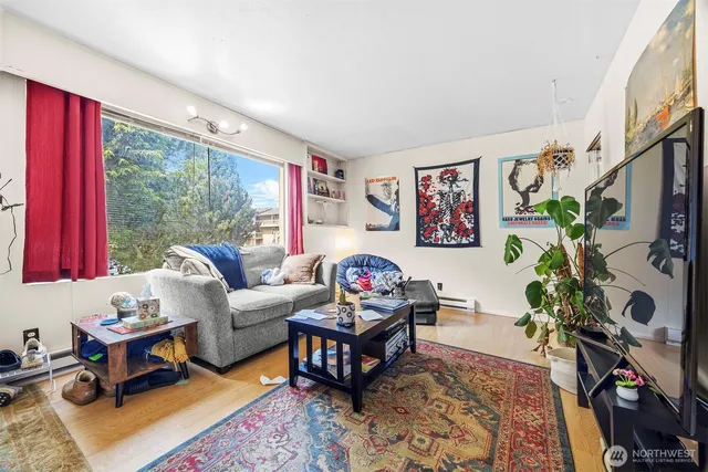a living room with furniture a bookshelf and a window