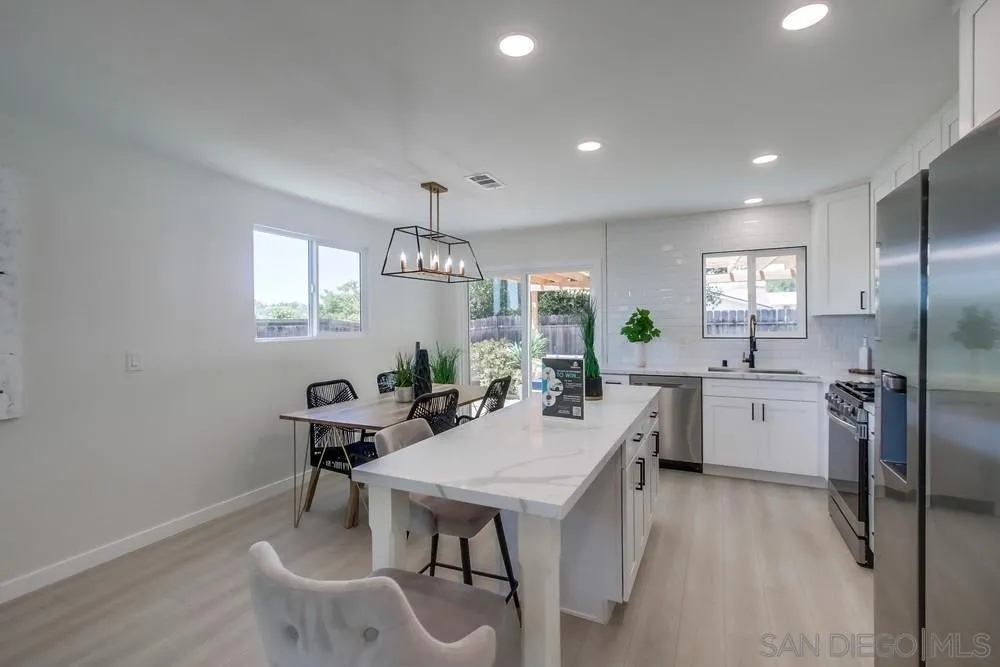 12736 Roberto Way Poway, CA 92064 - Photo 9 of 34 a kitchen with a table chairs refrigerator and cabinets