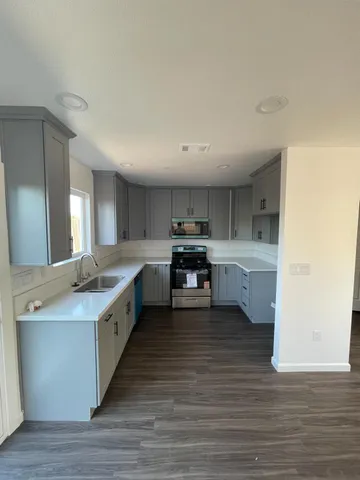a large kitchen with a stove top oven and sink