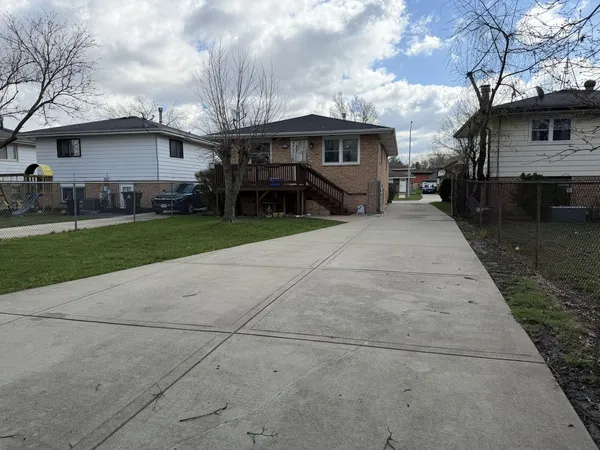 a front view of a house with a garden and trees