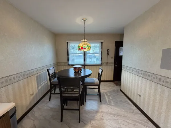 a dining room with furniture a chandelier and wooden floor
