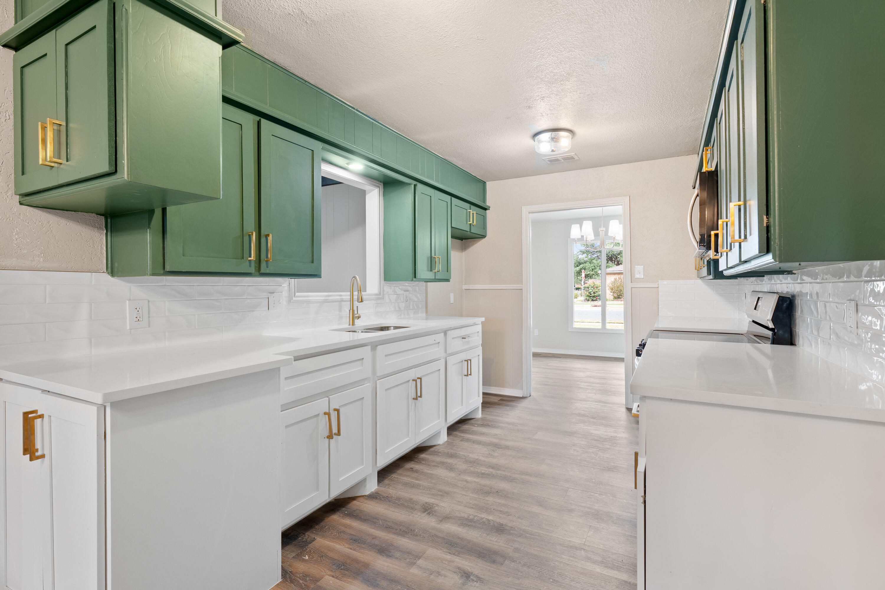 7902 Lynnhaven Avenue Lubbock, TX 79423 - Photo 12 of 35 a large white kitchen with a sink and a large mirror