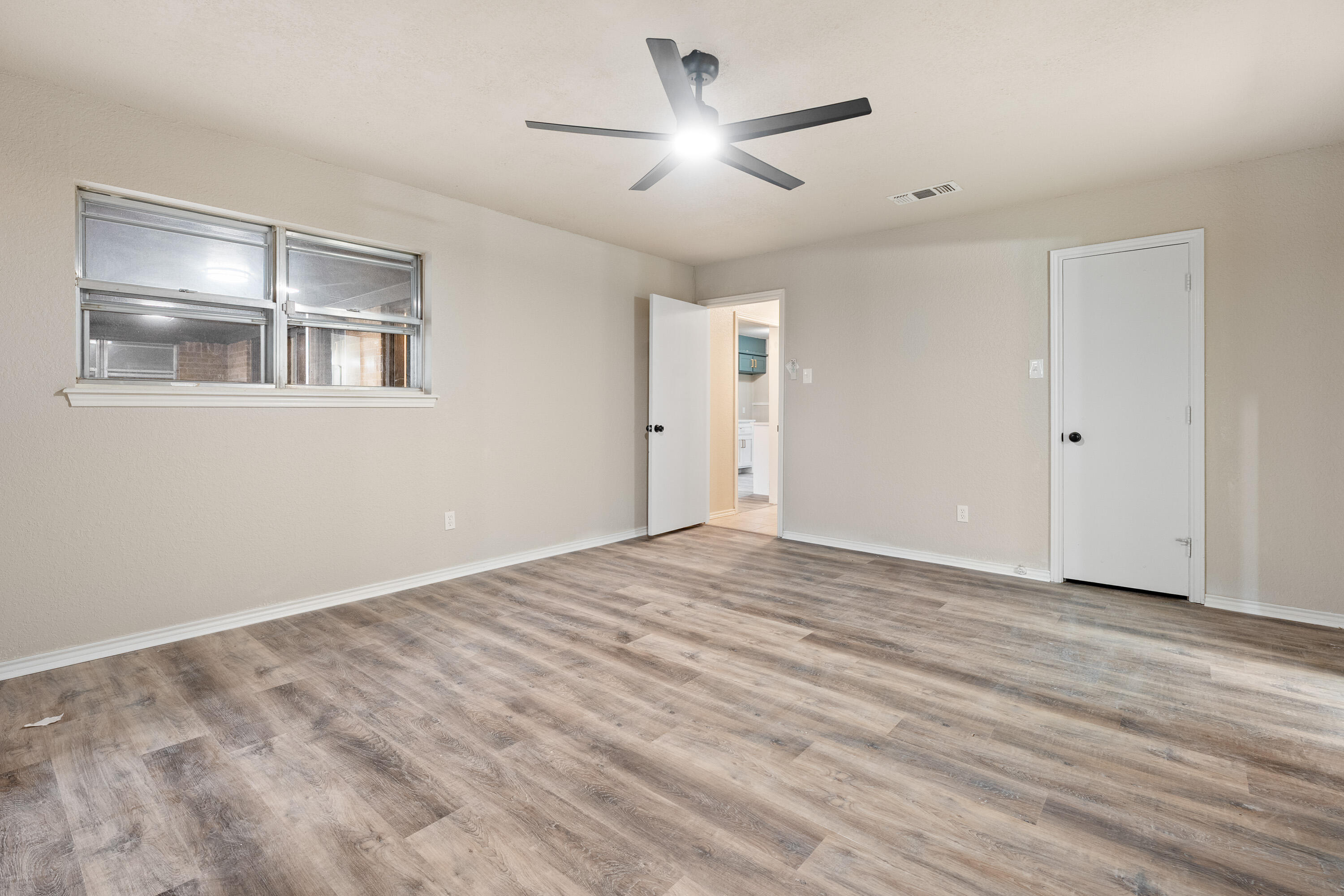 7902 Lynnhaven Avenue Lubbock, TX 79423 - Photo 14 of 35 a view of empty room with wooden floor and fan