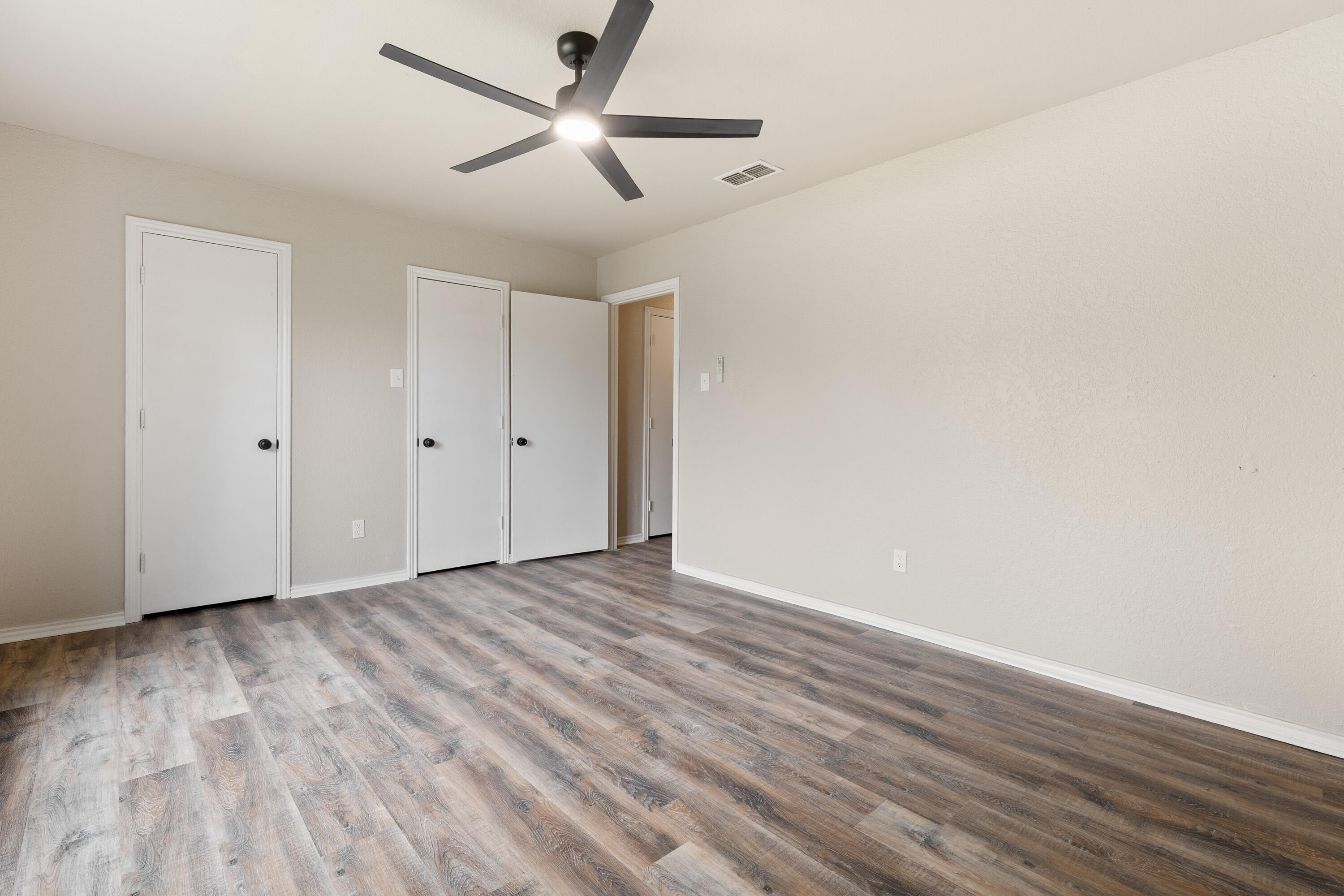 7902 Lynnhaven Avenue Lubbock, TX 79423 - Photo 17 of 35 an empty room with wooden floor and a ceiling fan