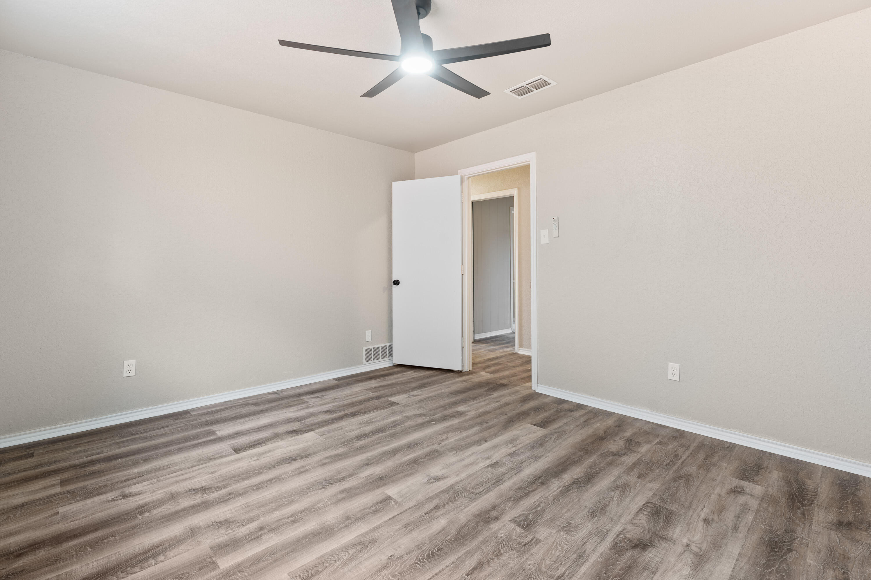 7902 Lynnhaven Avenue Lubbock, TX 79423 - Photo 22 of 35 a view of an empty room with wooden floor