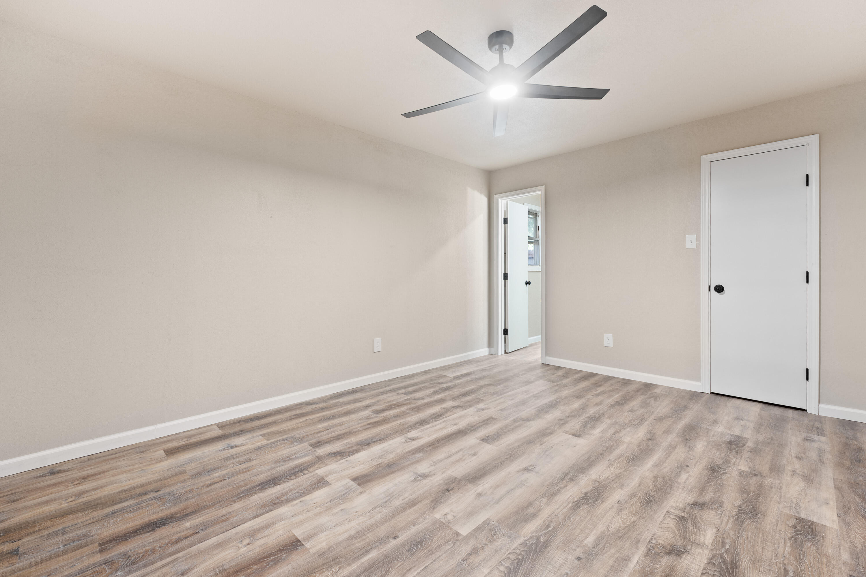 7902 Lynnhaven Avenue Lubbock, TX 79423 - Photo 28 of 35 an empty room with wooden floor and a ceiling fan