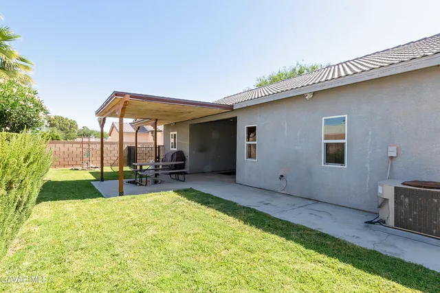 a backyard of a house with table and sofas