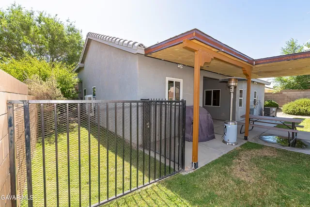 a view of a balcony with table and chairs potted plants with wooden fence