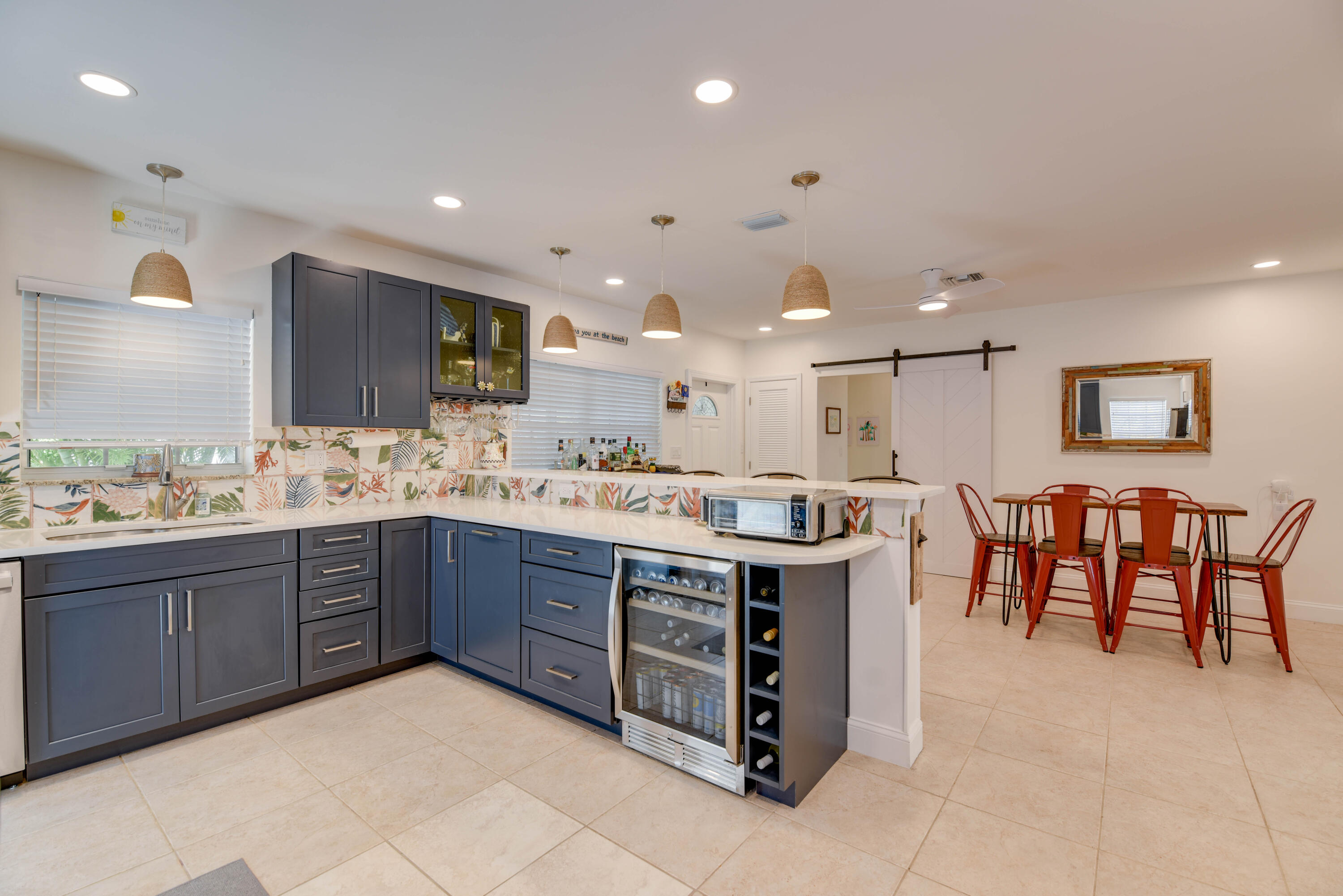 a large kitchen with stainless steel appliances granite countertop a table and chairs in it